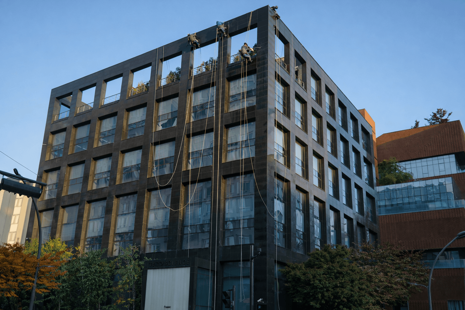 로프 작업자가 외벽을 청소하는 대형 건물 전경